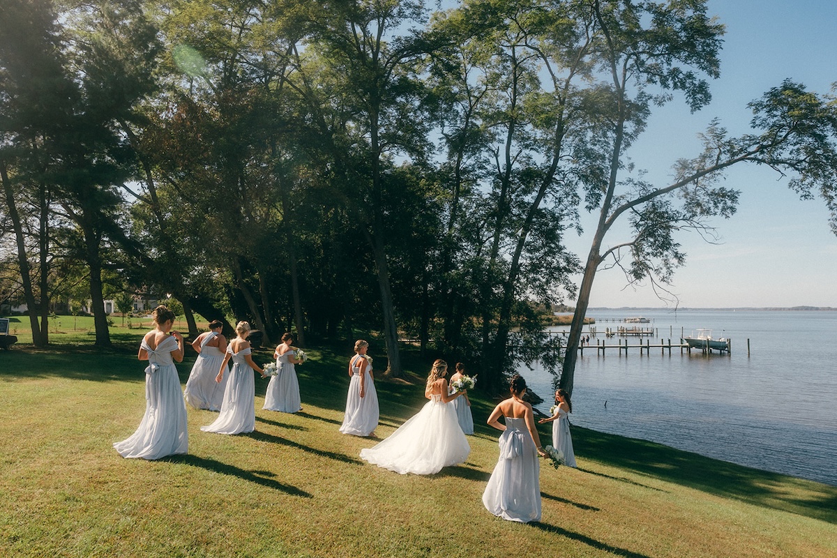 Bride and her bridesmaids walking out towards the waterfront on the private estate